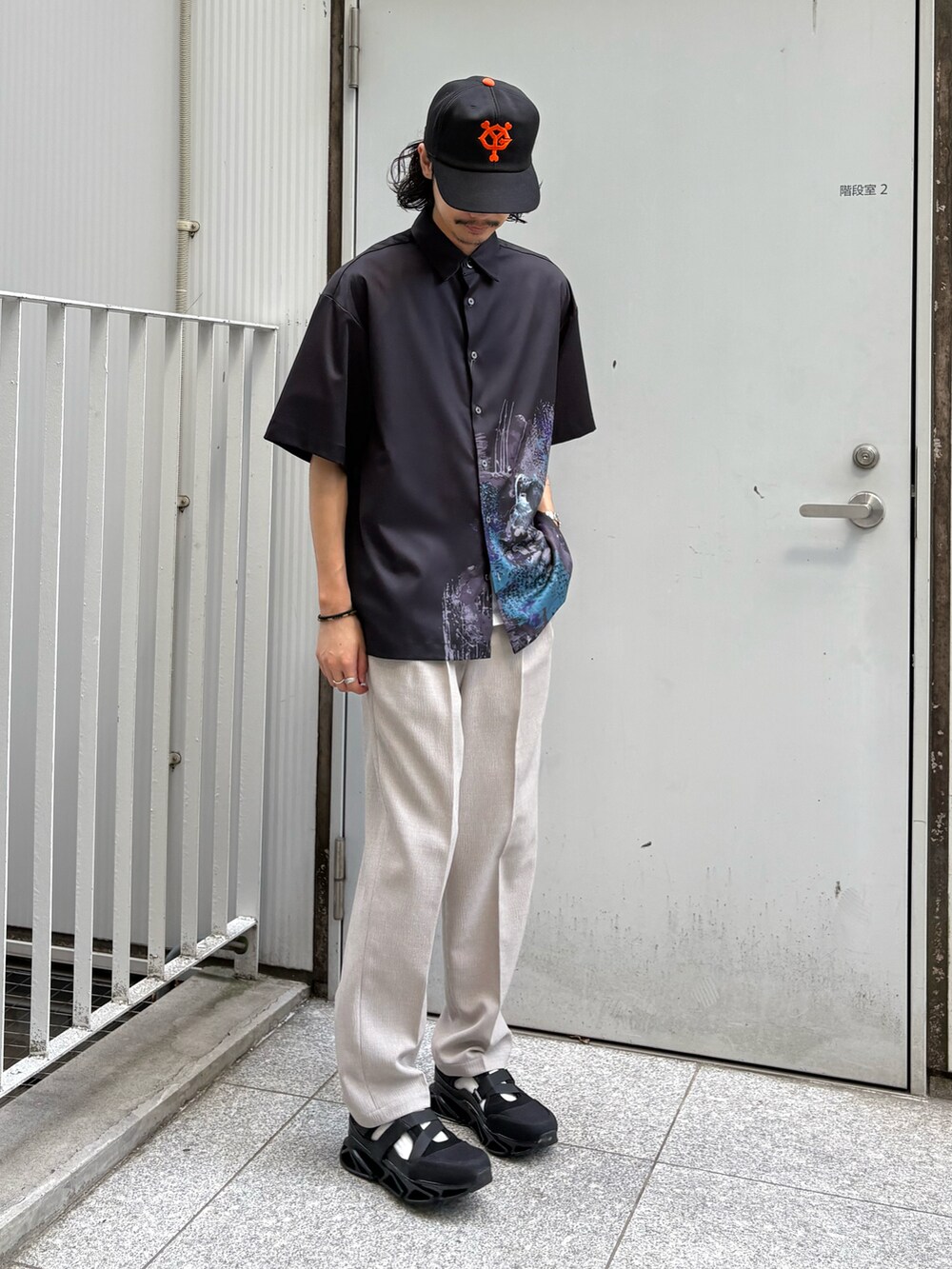 ブラック系のシャツ/ブラウス、ベージュ系のその他パンツ、ブラック系のサンダルを着用したメンズの春コーディネートの2枚目の写真