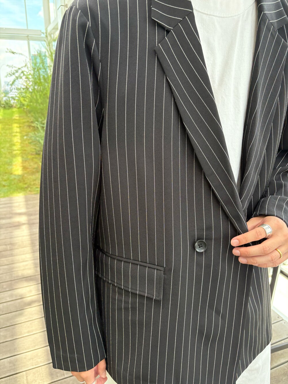 ブラック系のテーラードジャケット、ホワイト系のその他パンツを着用したメンズの夏コーディネートの3枚目の写真