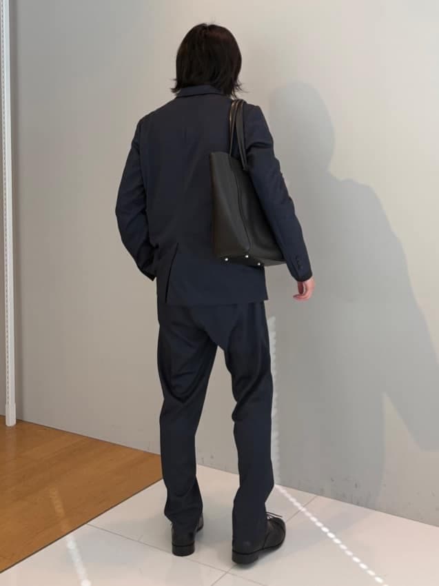 ブルー系のセットアップ、ブラック系のドレスシューズを着用したメンズの冬コーディネートの3枚目の写真