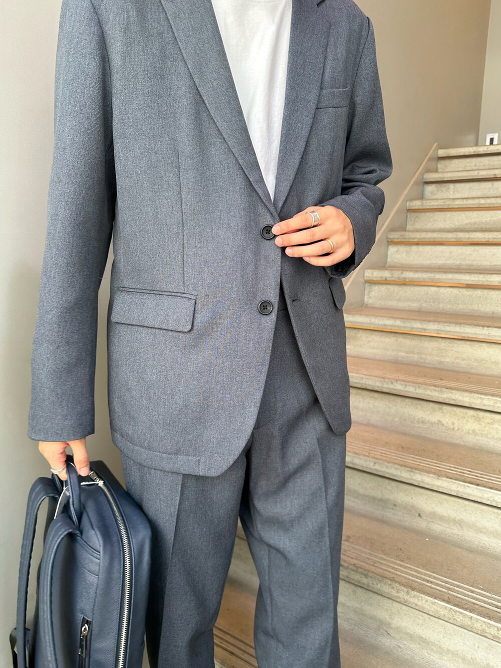 グレー系のセットアップ、ブルー系のバックパック/リュック、ブラック系のその他シューズを着用したメンズの夏コーディネートの4枚目の写真