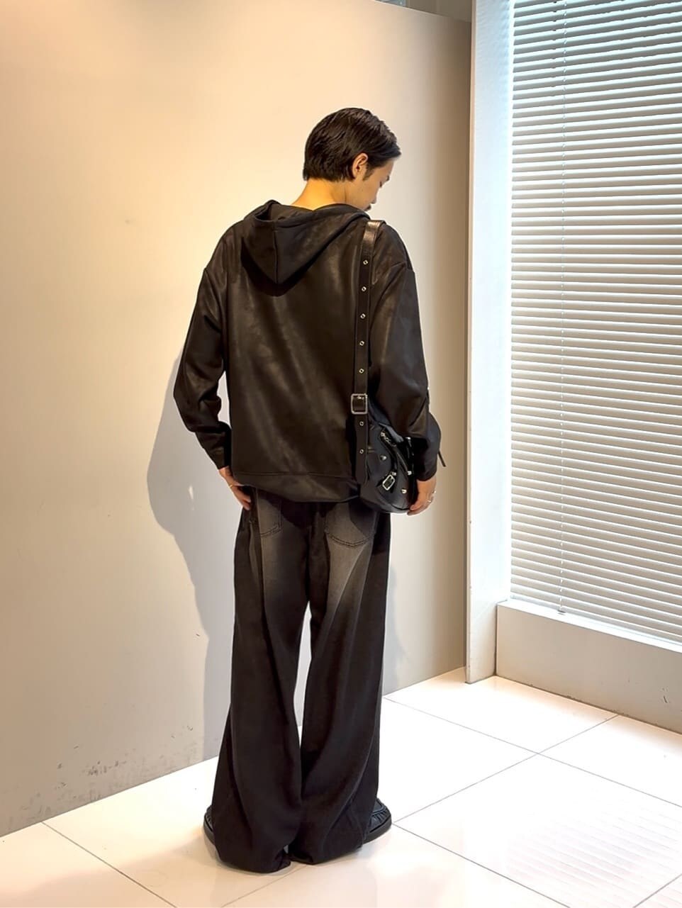 ブラック系のパーカー、ブルー系のドレスシューズ、ブラック系のショルダーバッグを着用したメンズの夏コーディネートの2枚目の写真
