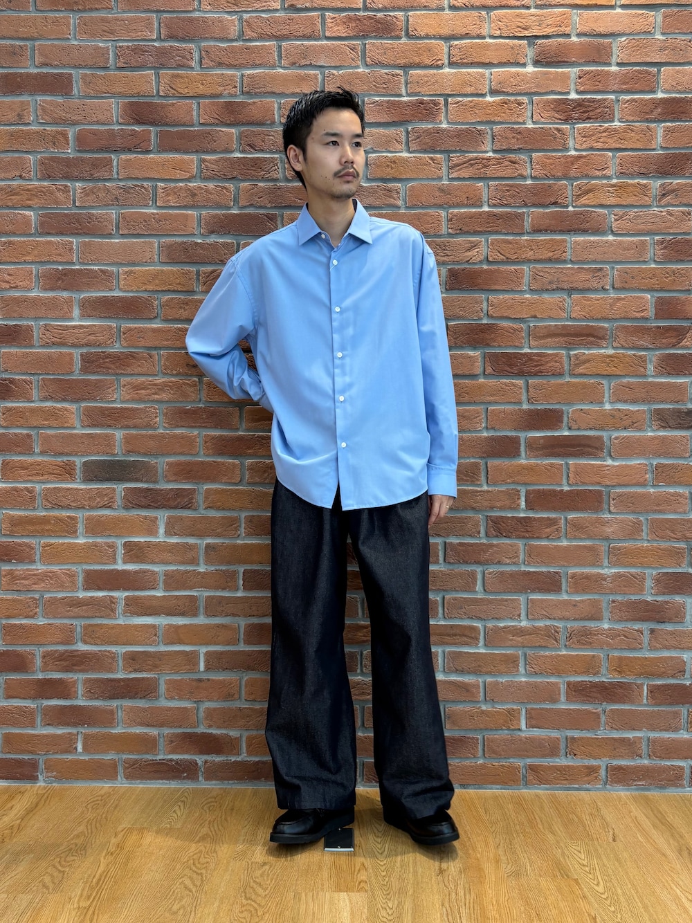 ブルー系のビジネスシャツ、ブルー系のデニムパンツ、ブラック系のドレスシューズを着用したメンズの夏コーディネートの3枚目の写真