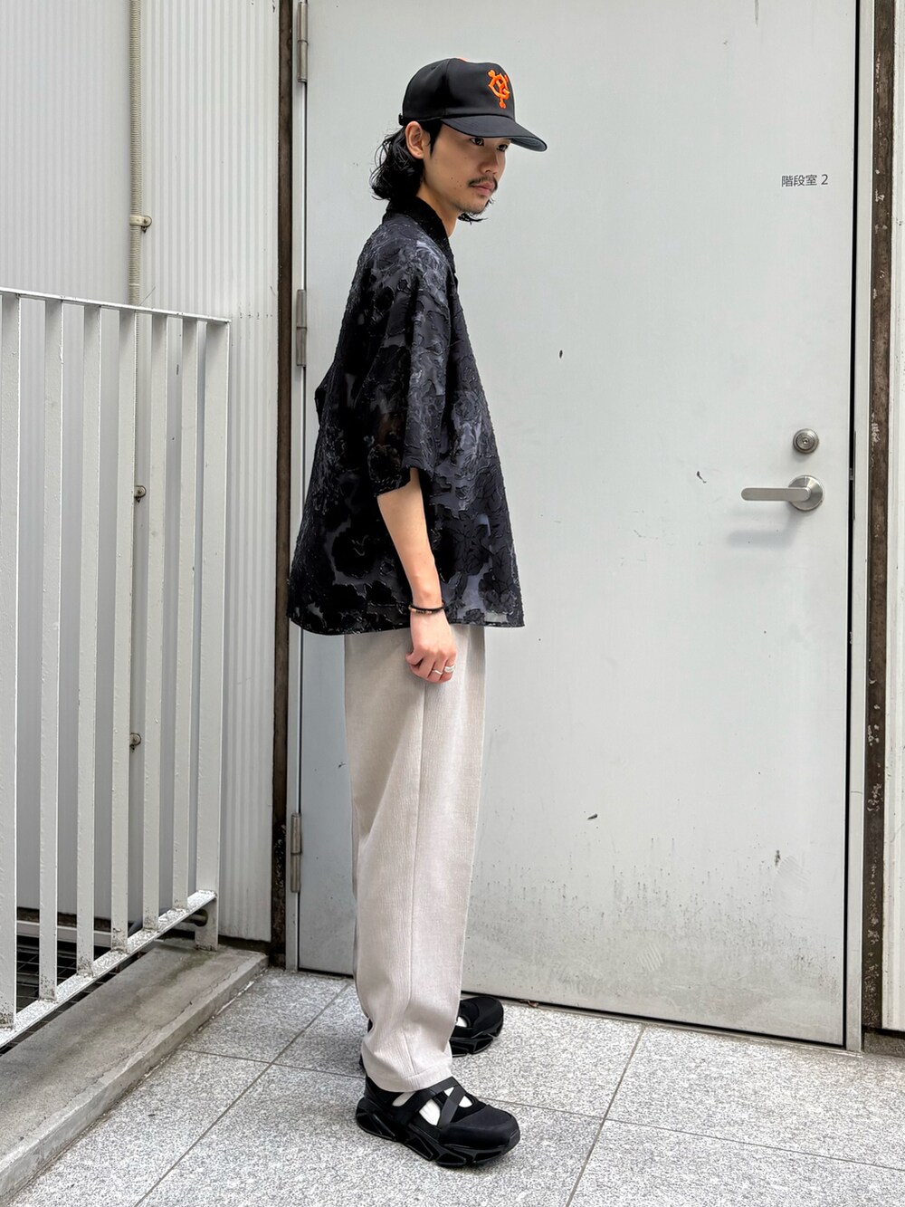 ブラック系のシャツ/ブラウス、ベージュ系のその他パンツ、ブラック系のサンダルを着用したメンズの春コーディネートの2枚目の写真