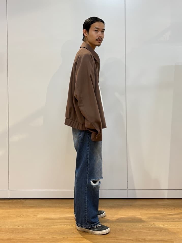 ブルー系のデニムパンツ、ブラウン系のブルゾンを着用したメンズの夏コーディネートの3枚目の写真