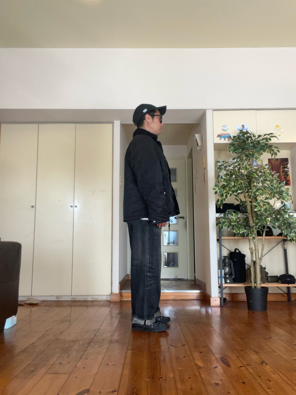 ブラック系のミリタリージャケット、ホワイト系のTシャツ/カットソー、ブラック系のスニーカーを着用したメンズの春コーディネートの2枚目の写真