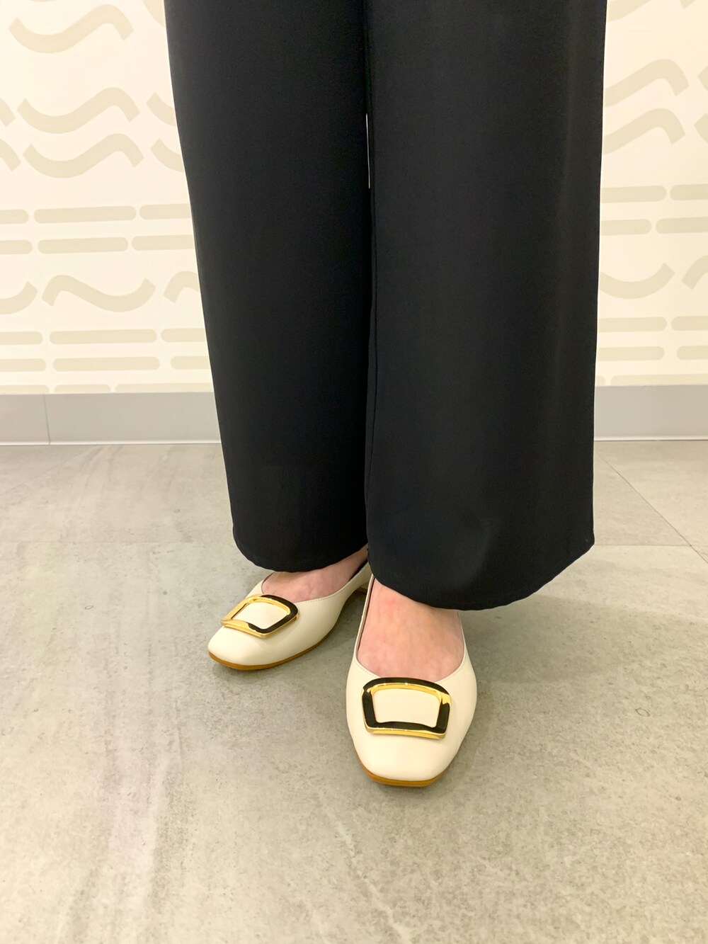 ベージュ系のパンプス、ピンク系のショルダーバッグを着用したレディースの春コーディネートの2枚目の写真