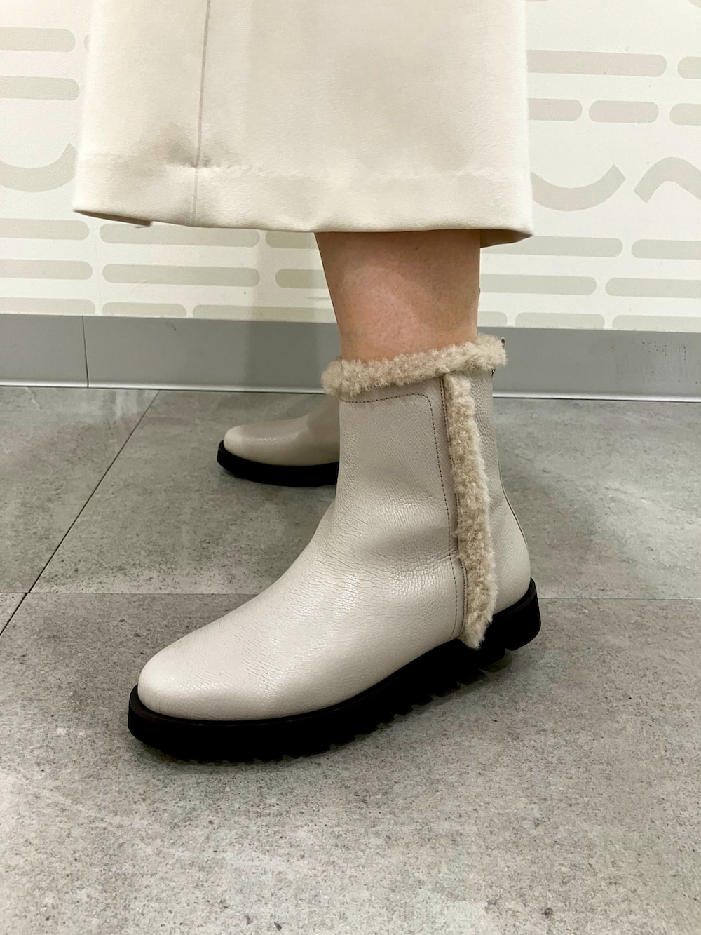 ベージュ系のブーツを着用したレディースの秋コーディネートの2枚目の写真