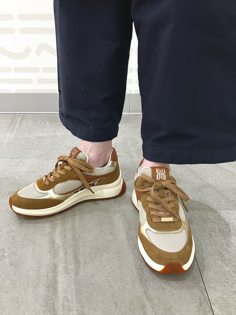 ブラウン系のスニーカーを着用したレディースの秋コーディネートの2枚目の写真