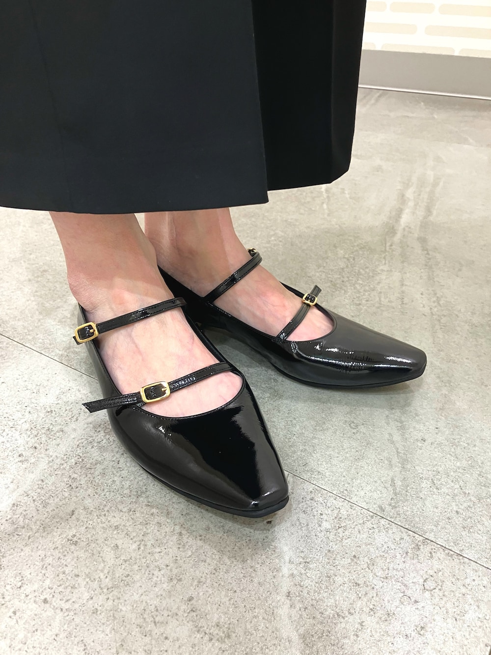 ブラック系のパンプスを着用したレディースの秋コーディネートの2枚目の写真