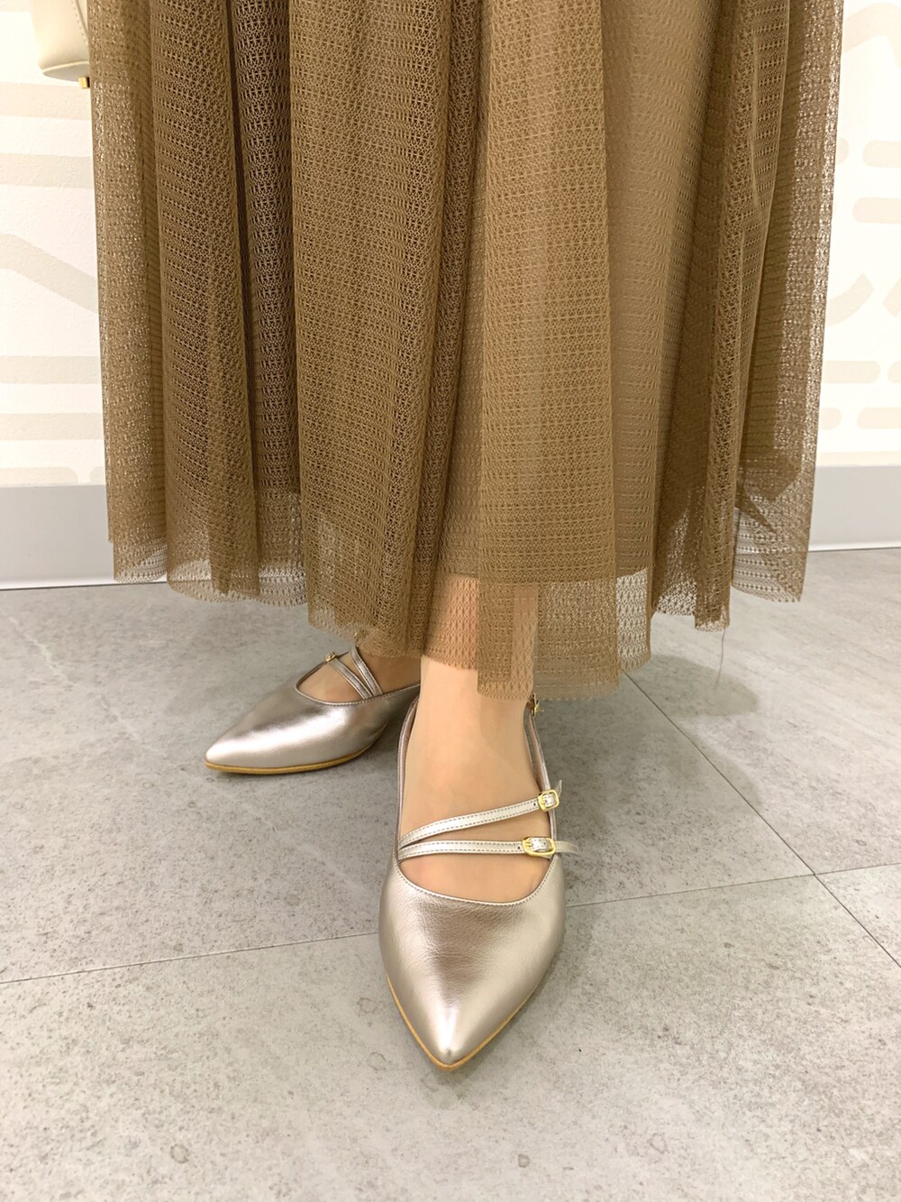 シルバー系のパンプス、ホワイト系のショルダーバッグを着用したレディースの春コーディネートの2枚目の写真