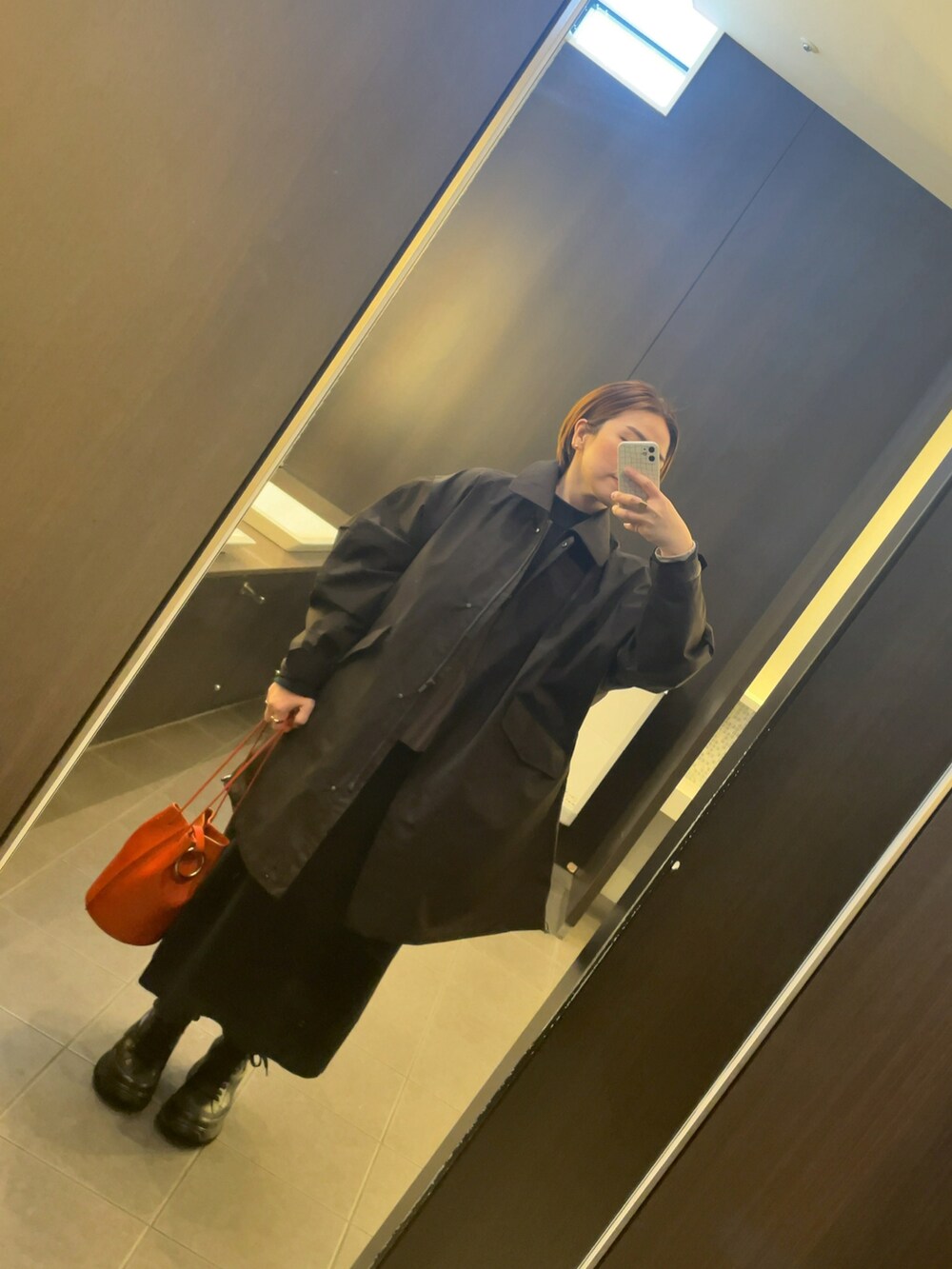 ブラック系のワンピース、ブラウン系のその他トップス、オレンジ系のトートバッグを着用したレディースの冬コーディネートの2枚目の写真