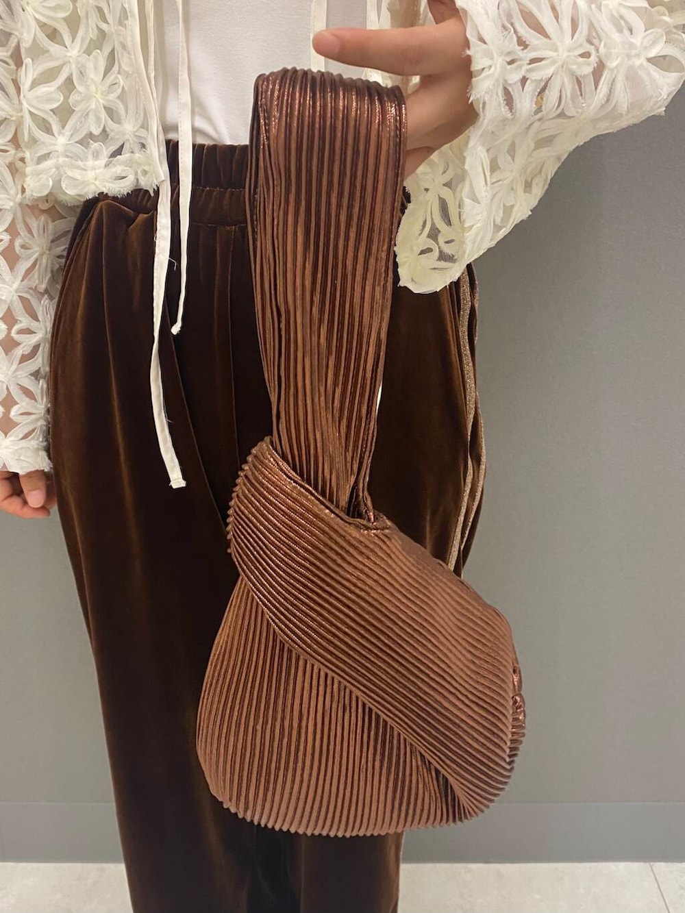 ブラウン系のハンドバッグ、ベージュ系のバレエシューズ、ホワイト系のシャツ/ブラウスを着用したレディースの夏コーディネートの5枚目の写真