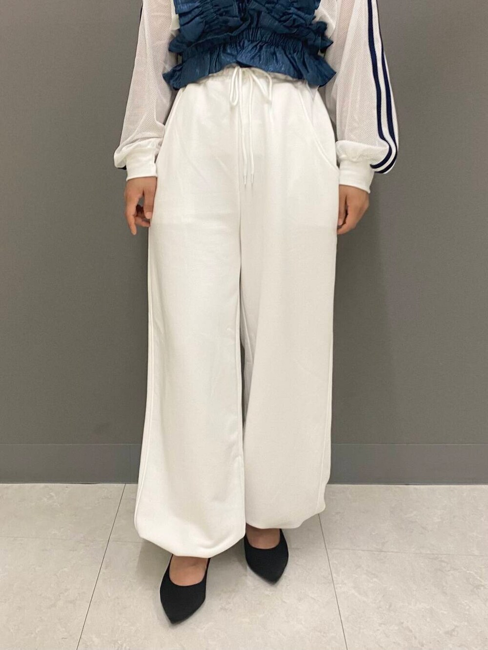 ブラック系のパンプス、ホワイト系のスウェットパンツ、ホワイト系のTシャツ/カットソーを着用したレディースの夏コーディネートの3枚目の写真