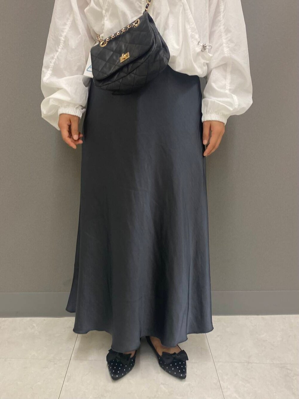 その他のパンプス、ブラック系のショルダーバッグ、ホワイト系のナイロンジャケットを着用したレディースの秋コーディネートの3枚目の写真