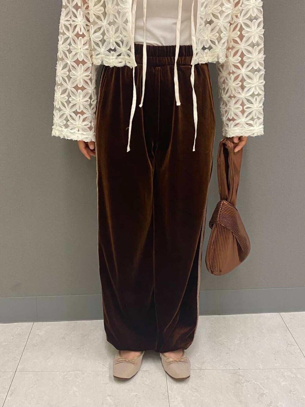 ブラウン系のハンドバッグ、ベージュ系のバレエシューズ、ホワイト系のシャツ/ブラウスを着用したレディースの夏コーディネートの3枚目の写真