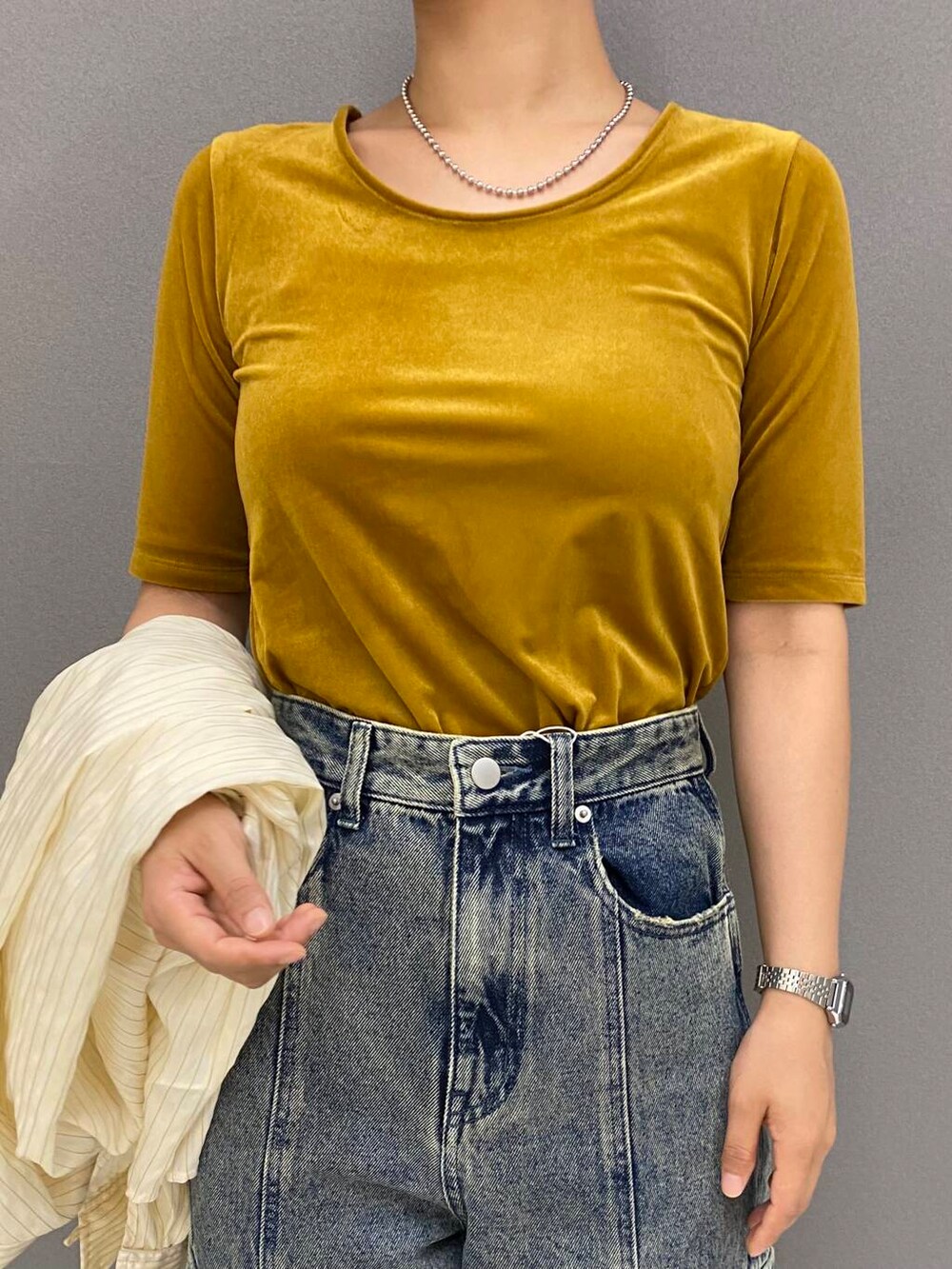 イエロー系のシャツ/ブラウス、ブラウン系のサンダル、グレー系のデニムパンツを着用したレディースの夏コーディネートの2枚目の写真