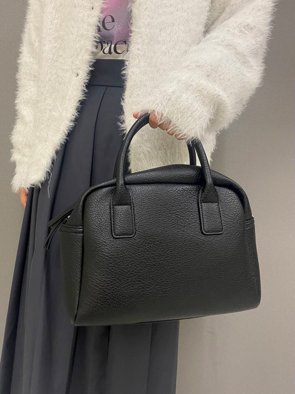 ブラック系のボストンバッグ、ブラック系のブーツ、ホワイト系のニット/セーターを着用したレディースの秋コーディネートの5枚目の写真