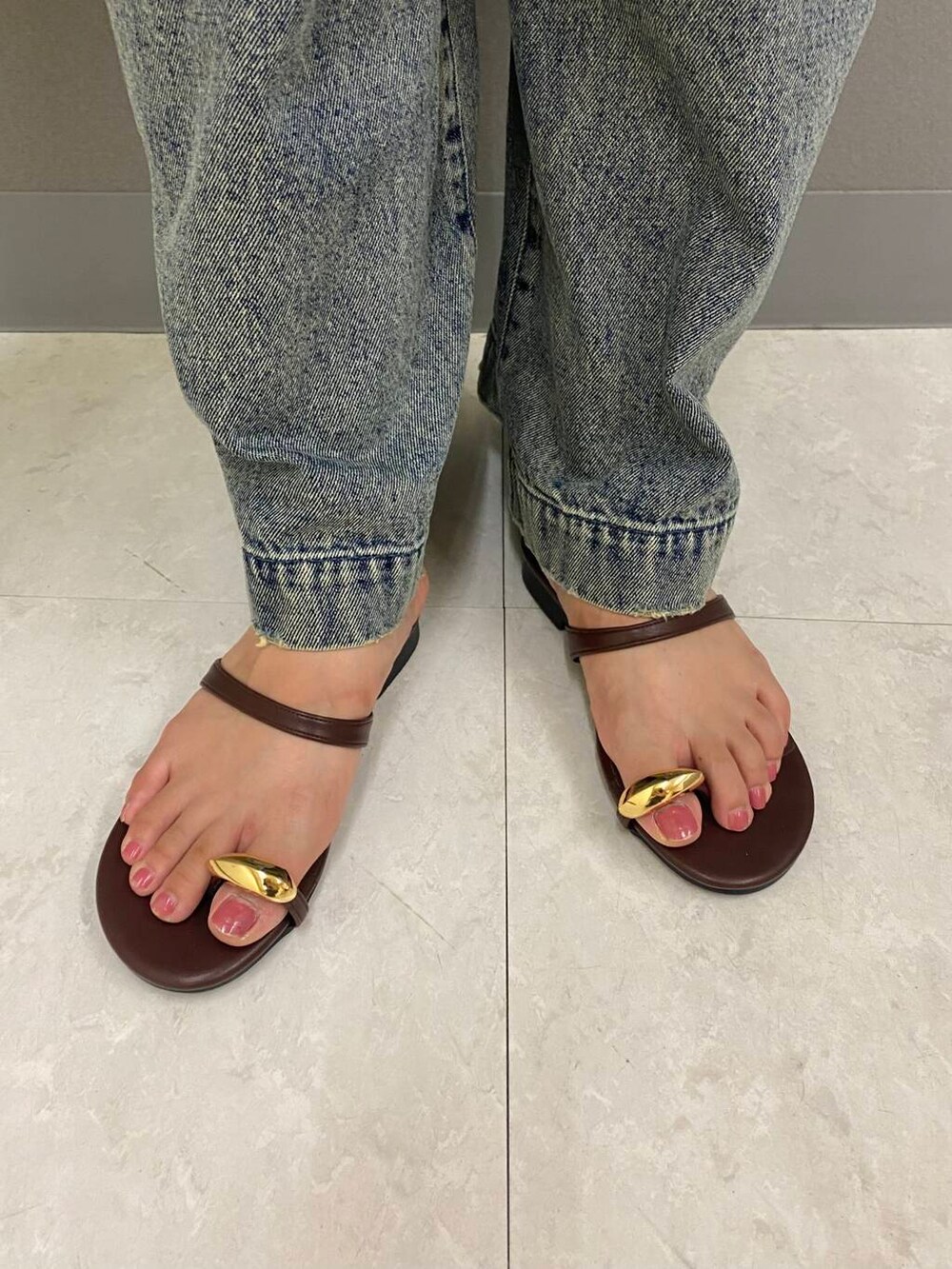 イエロー系のシャツ/ブラウス、ブラウン系のサンダル、グレー系のデニムパンツを着用したレディースの夏コーディネートの4枚目の写真