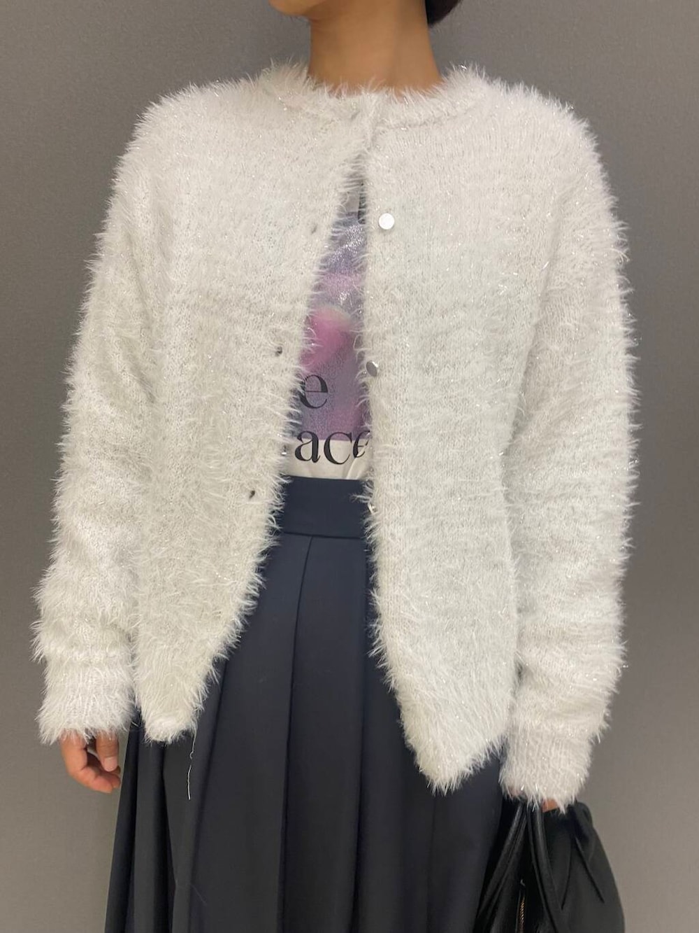 ブラック系のボストンバッグ、ブラック系のブーツ、ホワイト系のニット/セーターを着用したレディースの秋コーディネートの2枚目の写真