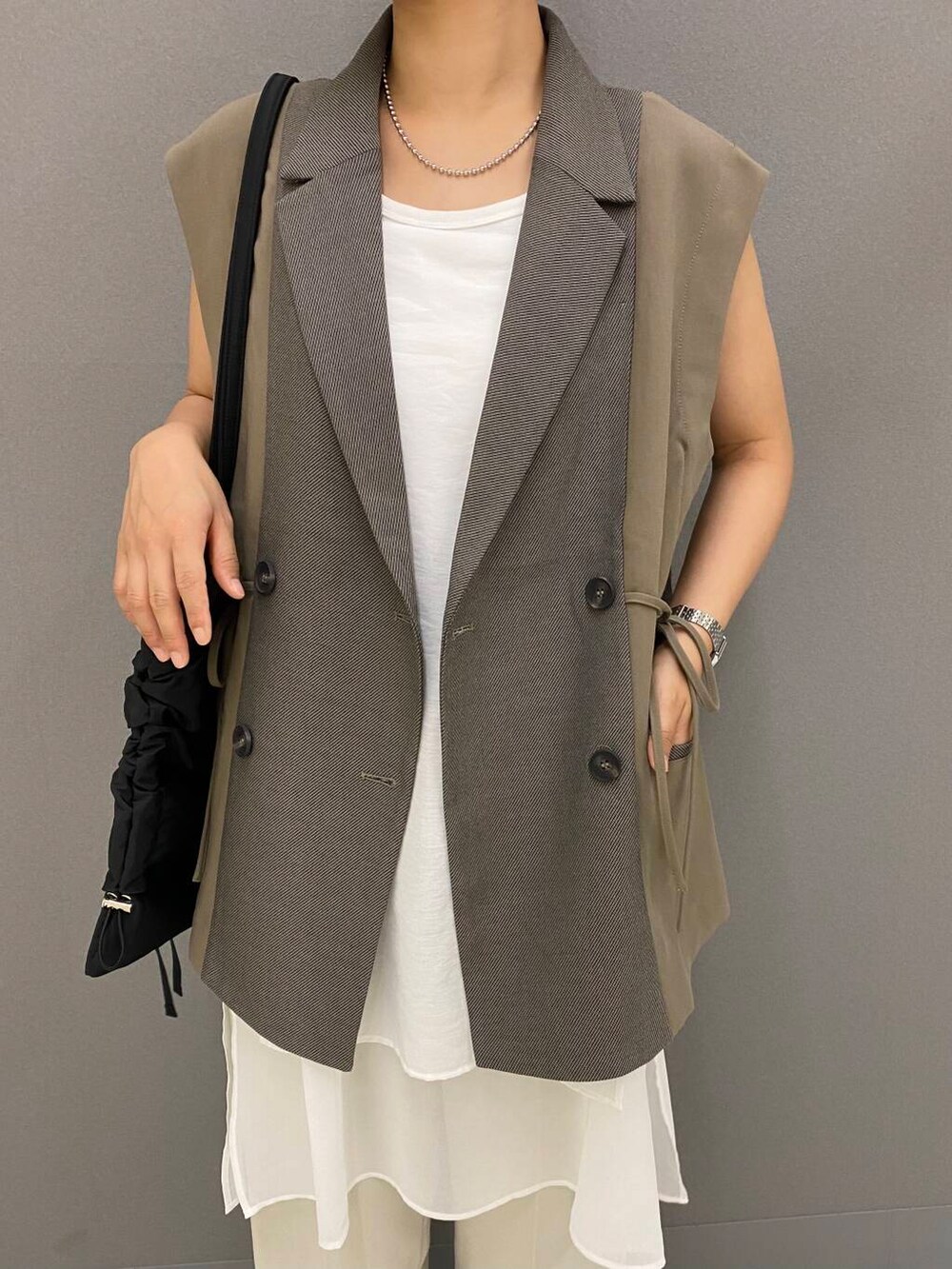 ホワイト系のタンクトップ、ベージュ系のその他パンツ、ブラック系のその他シューズを着用したレディースの夏コーディネートの2枚目の写真