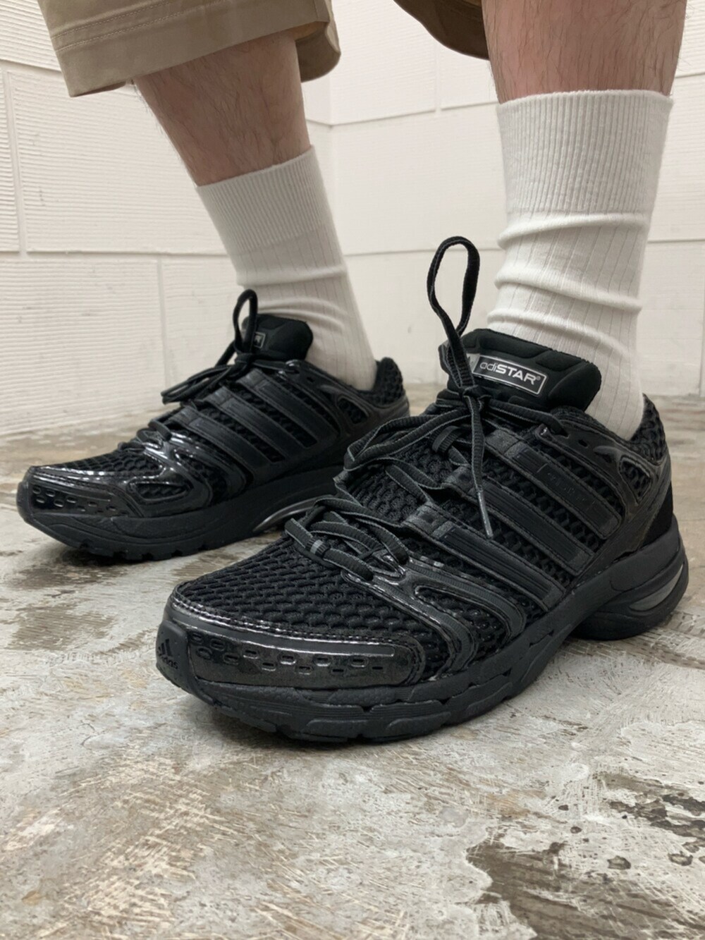 ブラック系のスニーカー、ブラック系のトップス、ベージュ系のその他パンツを着用したメンズの夏コーディネートの6枚目の写真