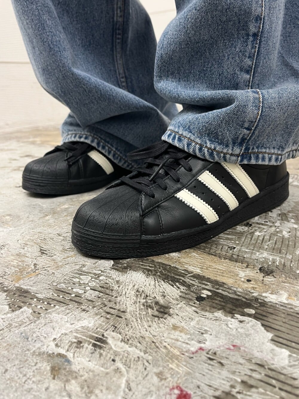 ブラック系のシューズ、ブルー系のデニムパンツ、ブラック系のTシャツ/カットソーを着用したメンズの春コーディネートの6枚目の写真