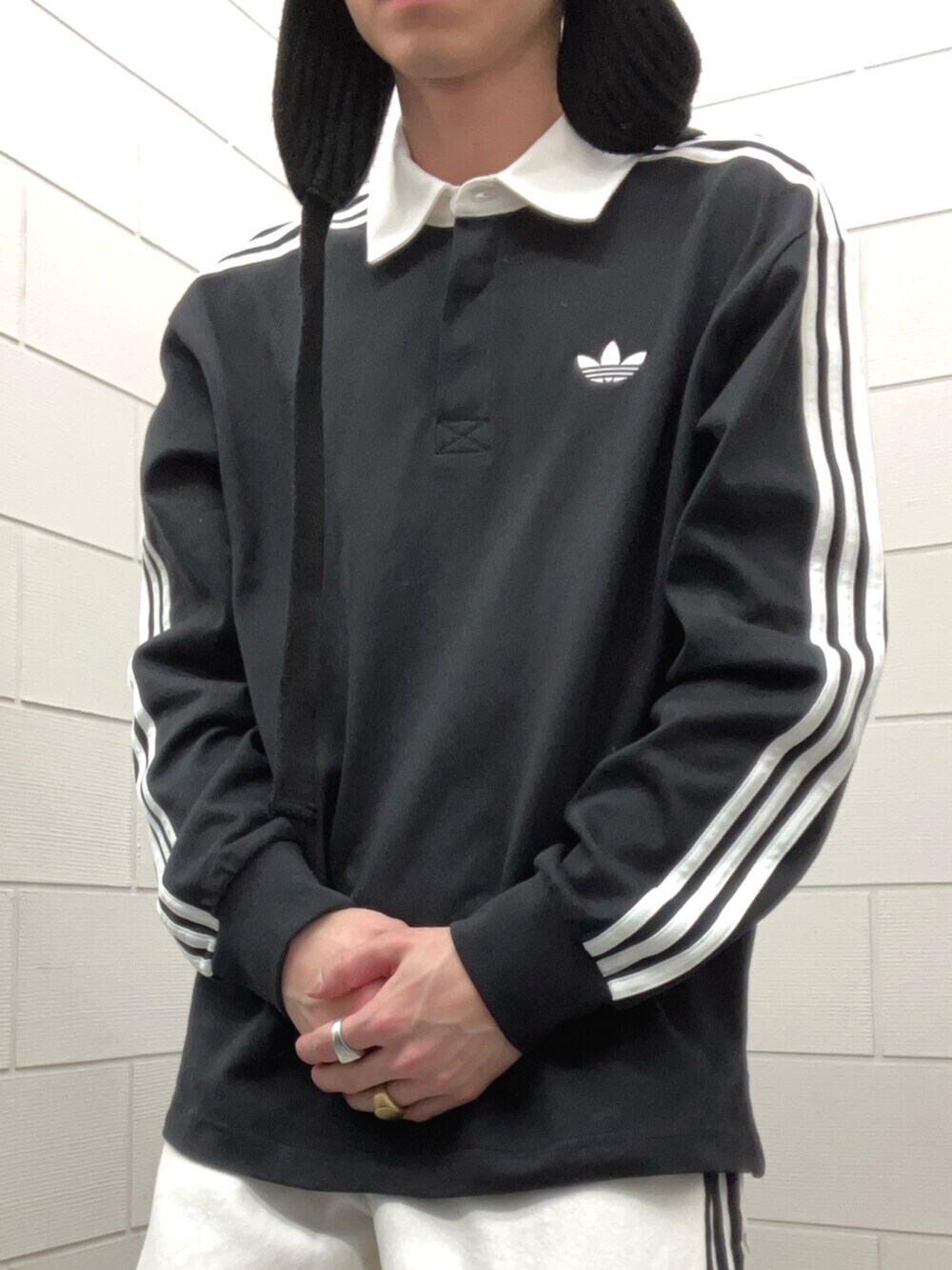 ベージュ系のスニーカー、ブラック系のポロシャツを着用したメンズの春コーディネートの4枚目の写真