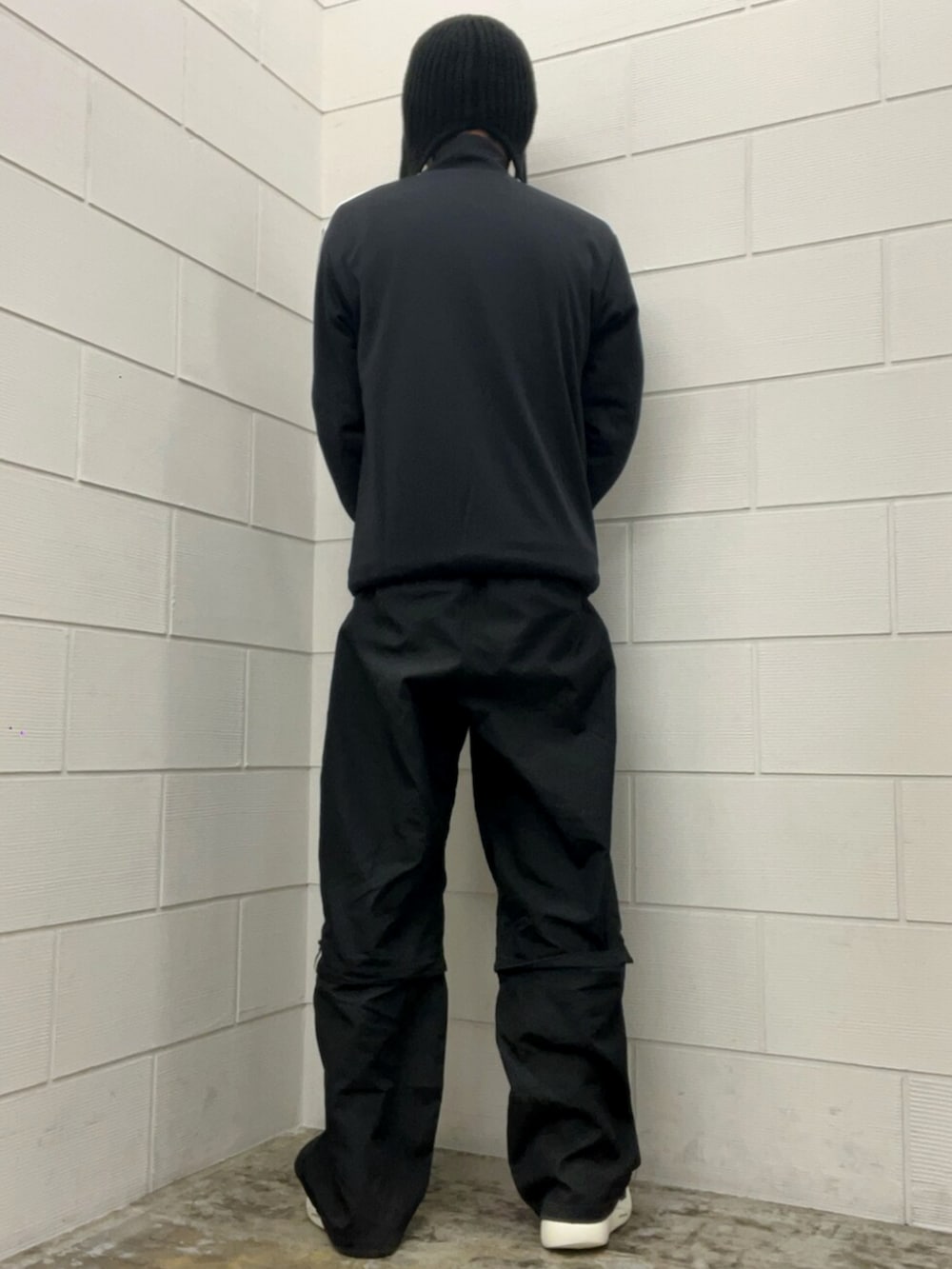 ブラック系のその他パンツ、ブラック系のトップス、ホワイト系のスニーカーを着用したメンズの冬コーディネートの3枚目の写真