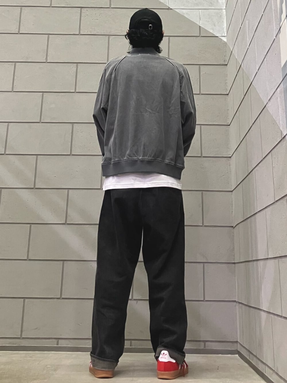 レッド系のスニーカー、グレー系のデニムジャケット、ホワイト系のトップスを着用したメンズの夏コーディネートの2枚目の写真