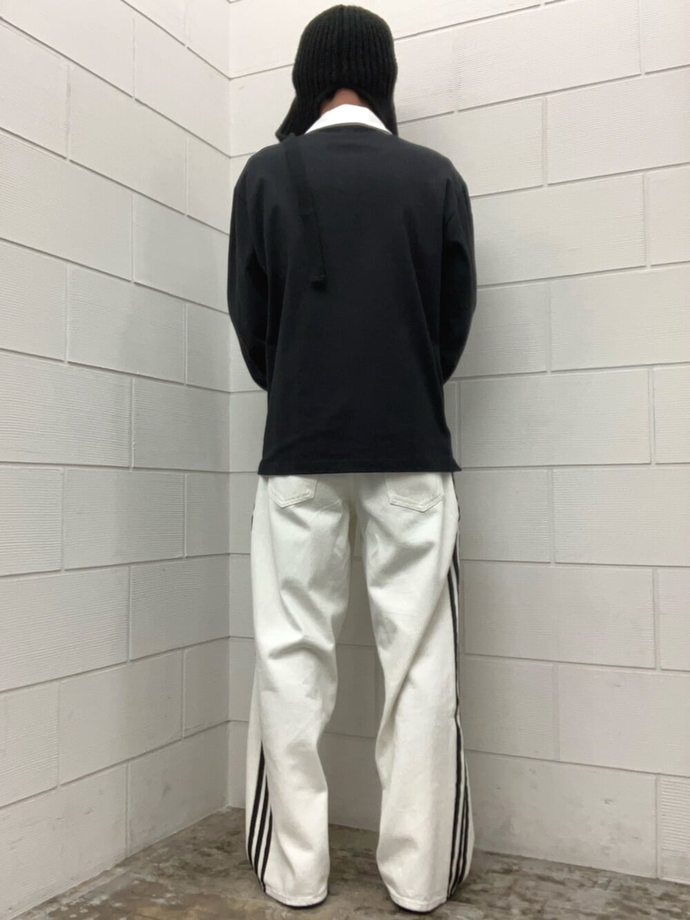 ベージュ系のスニーカー、ブラック系のポロシャツを着用したメンズの春コーディネートの3枚目の写真