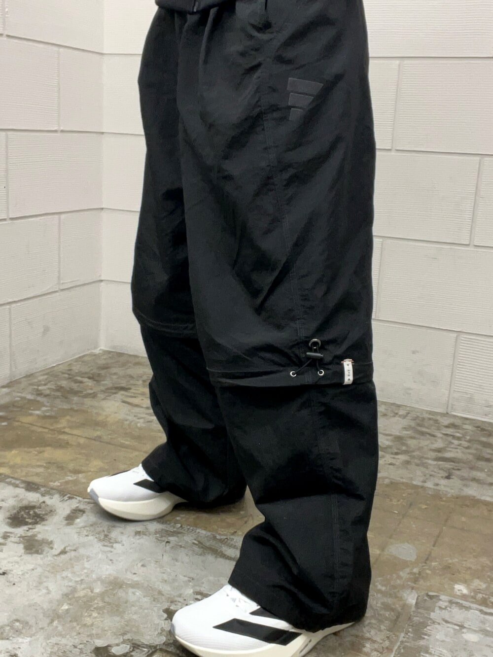 ブラック系のその他パンツ、ブラック系のトップス、ホワイト系のスニーカーを着用したメンズの冬コーディネートの5枚目の写真