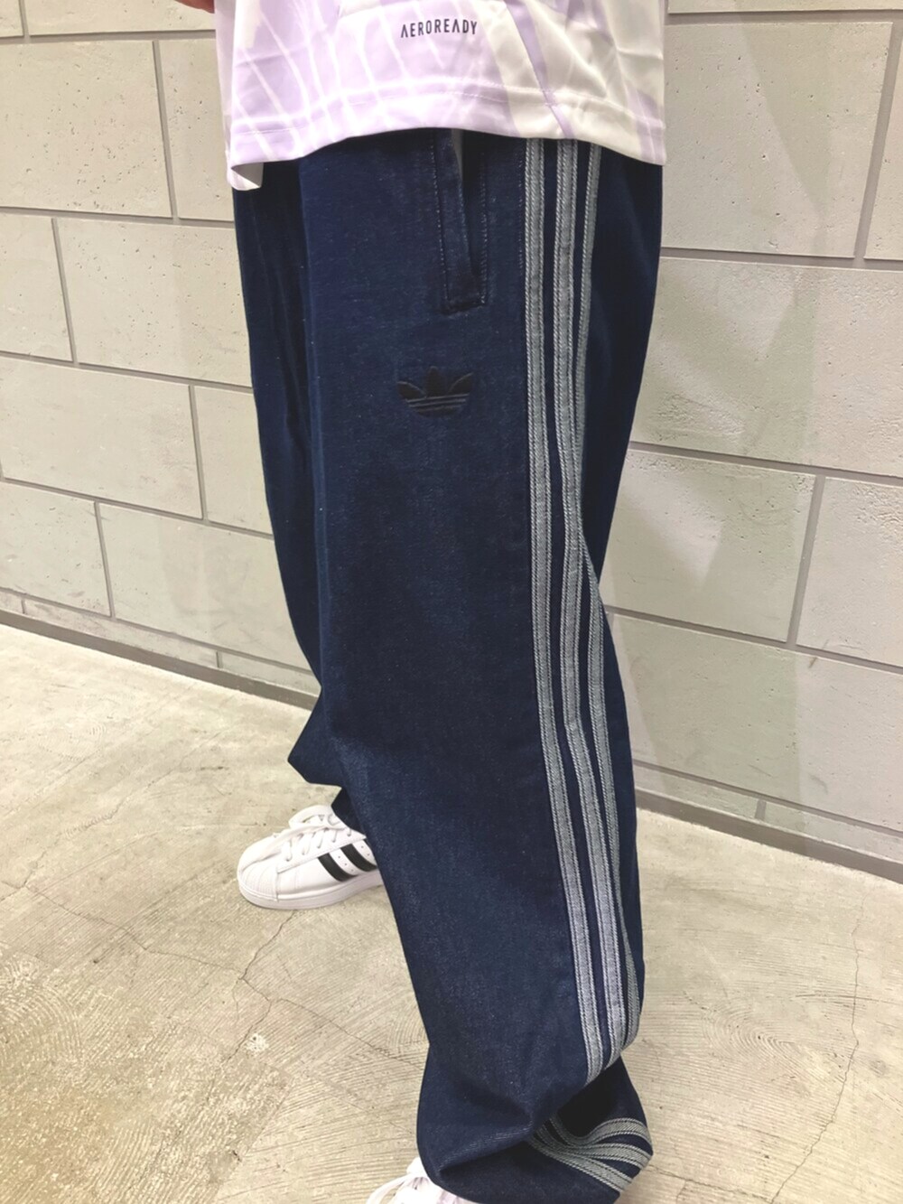 ホワイト系のスニーカー、ブルー系のデニムパンツ、ホワイト系のTシャツ/カットソーを着用したメンズの夏コーディネートの5枚目の写真