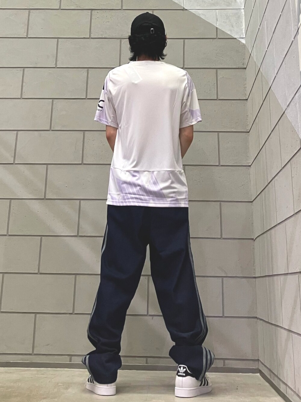 ホワイト系のスニーカー、ブルー系のデニムパンツ、ホワイト系のTシャツ/カットソーを着用したメンズの夏コーディネートの3枚目の写真