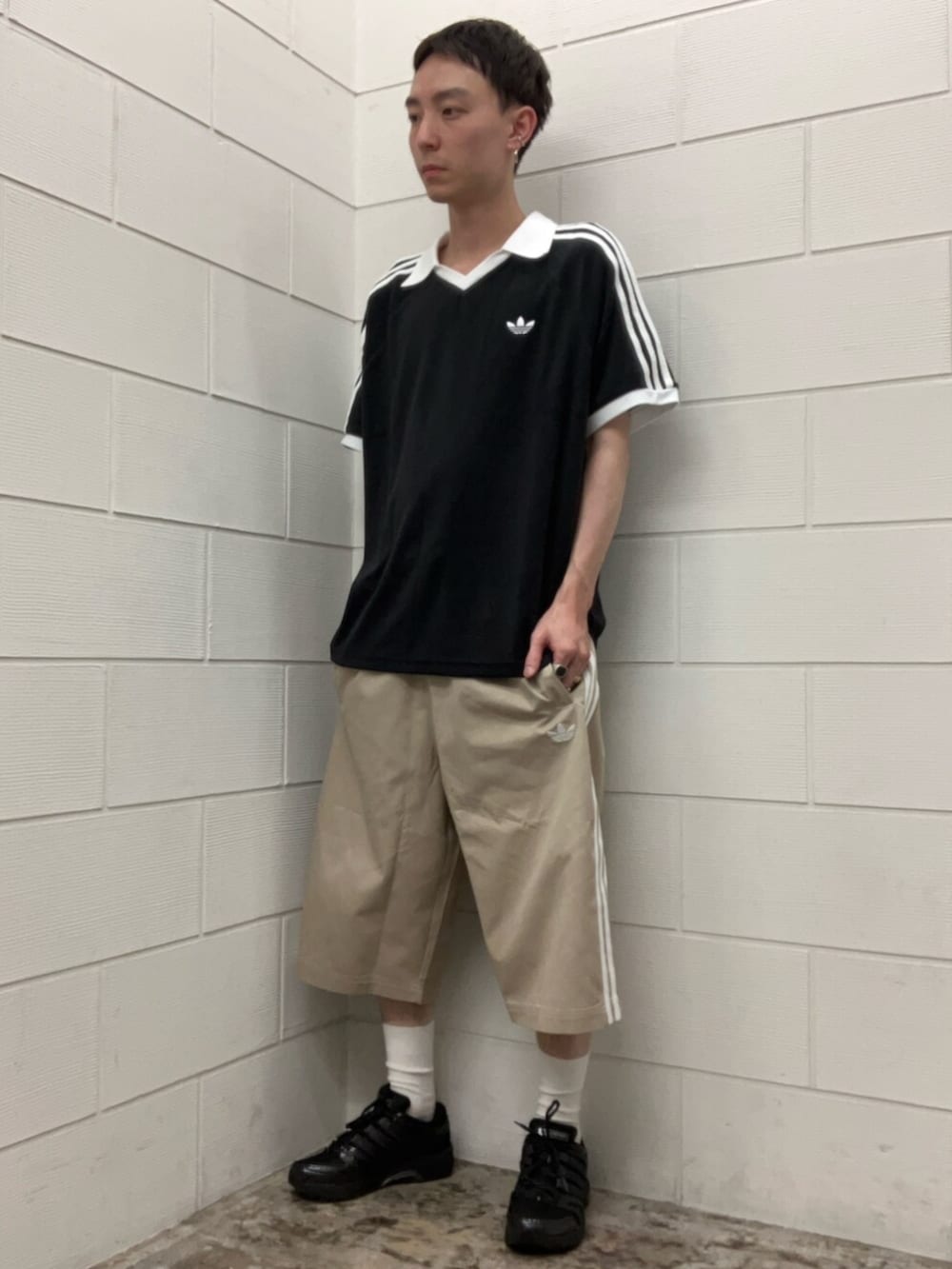 ブラック系のスニーカー、ブラック系のトップス、ベージュ系のその他パンツを着用したメンズの夏コーディネートの2枚目の写真
