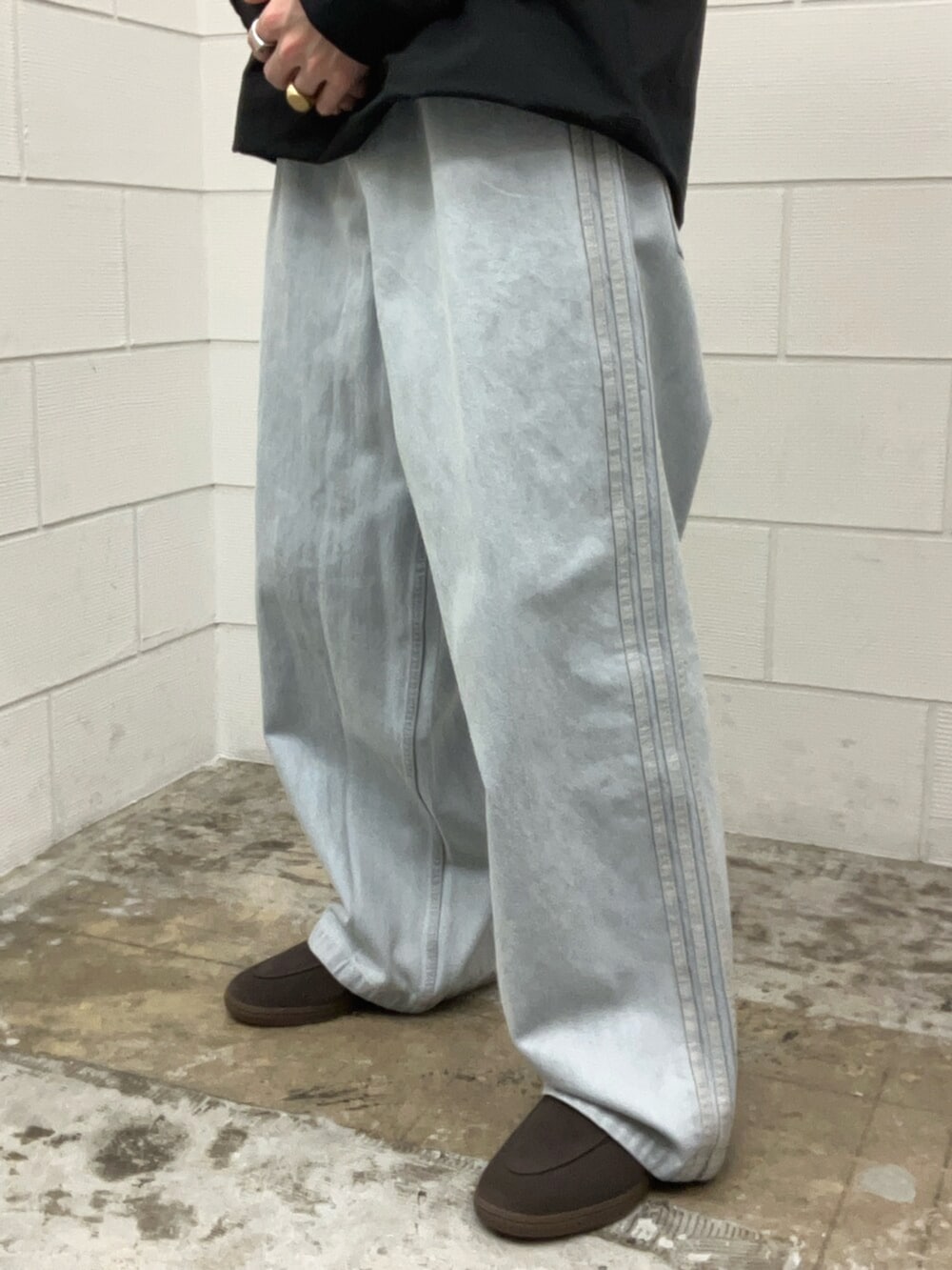 ブルー系のその他パンツ、ブラウン系のスニーカー、ブラック系のトップスを着用したメンズの春コーディネートの3枚目の写真