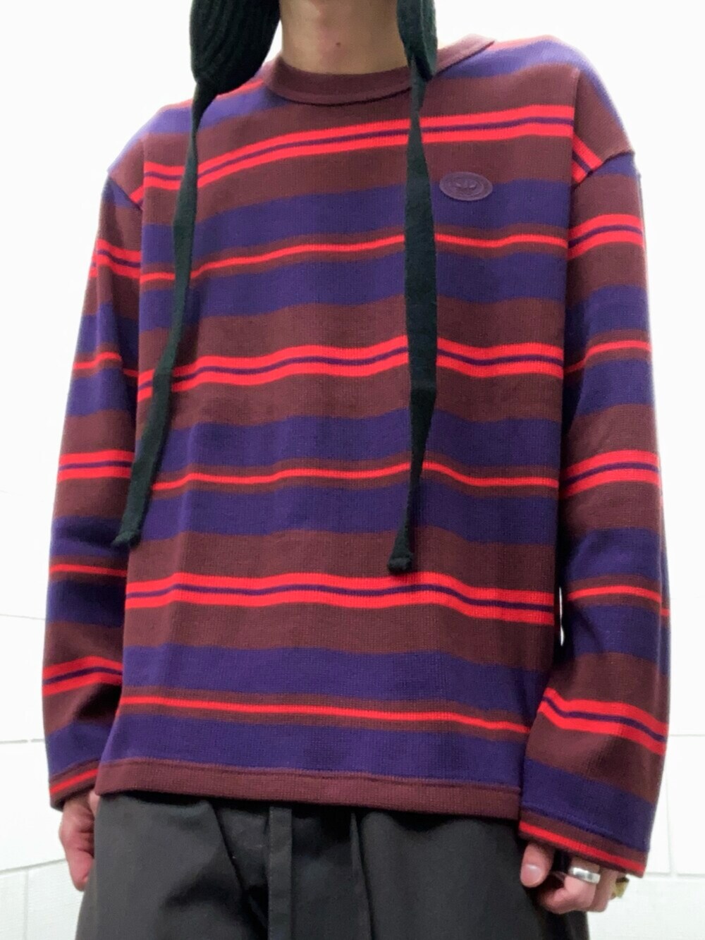 レッド系のTシャツ/カットソー、ホワイト系のスニーカーを着用したメンズの冬コーディネートの5枚目の写真