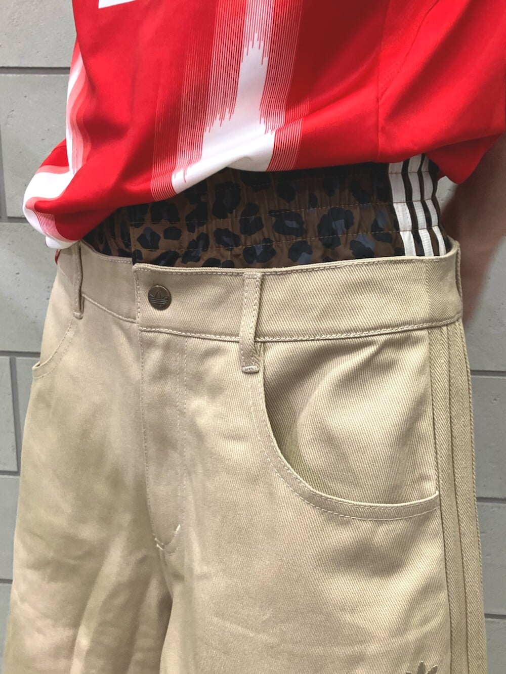 ベージュ系のその他パンツ、レッド系のスニーカー、レッド系のTシャツ/カットソーを着用したメンズの夏コーディネートの5枚目の写真