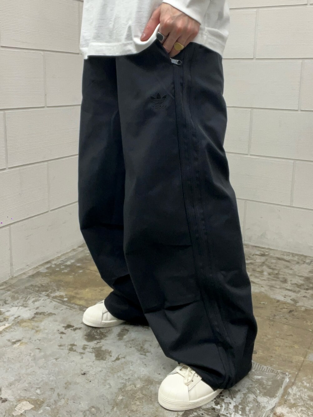 ホワイト系のシューズ、ブラック系のその他パンツ、ホワイト系のTシャツ/カットソーを着用したメンズの春コーディネートの5枚目の写真