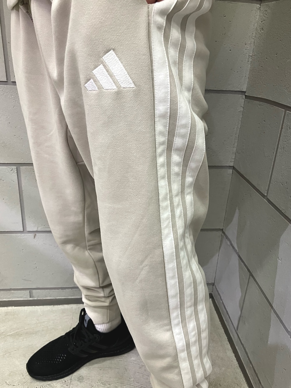 ホワイト系のスウェット、グレー系のスウェットパンツ、ブラック系のスニーカーを着用したメンズの冬コーディネートの3枚目の写真