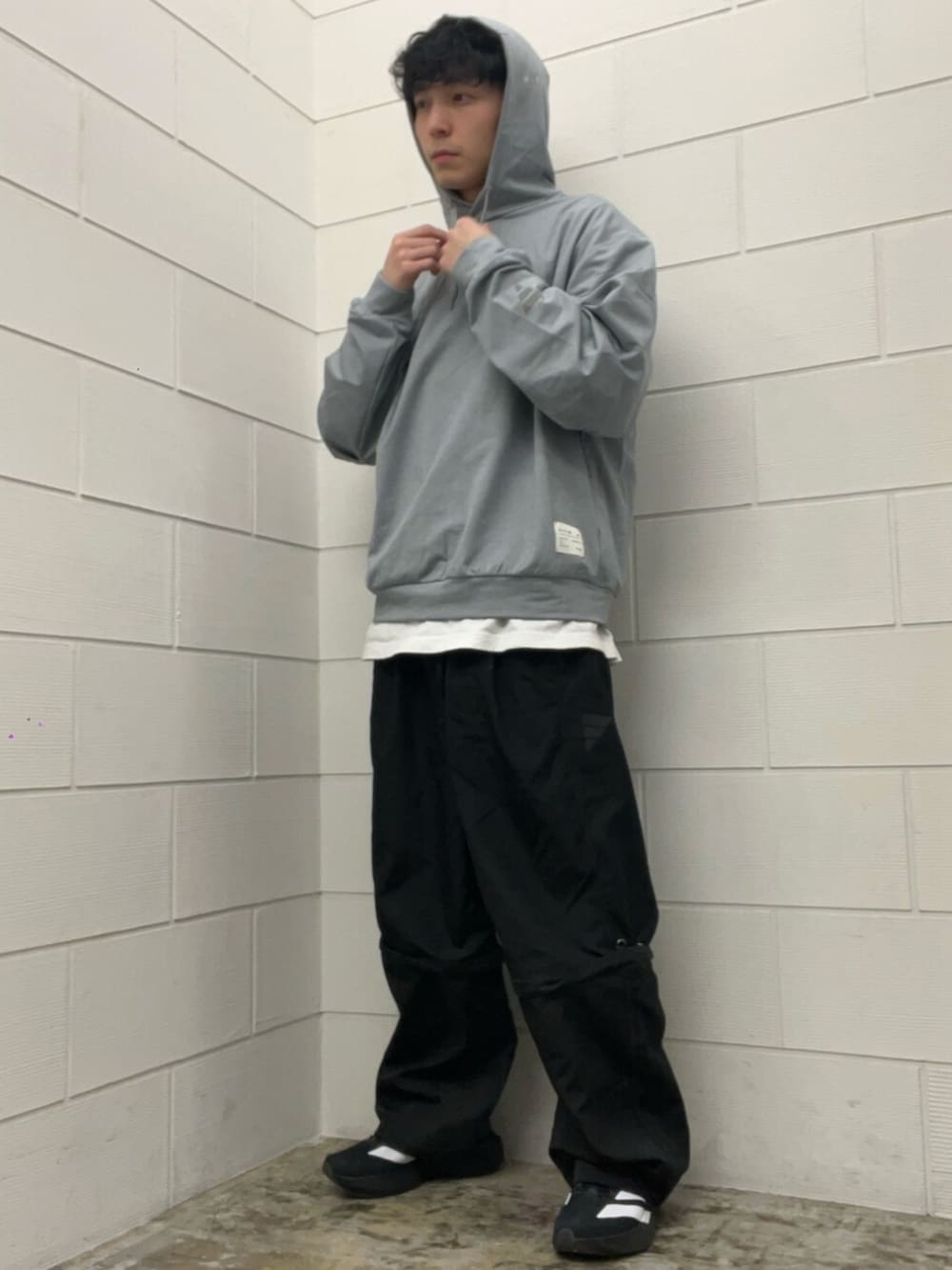 ブラック系のその他パンツ、ブラック系のスニーカー、グレー系のパーカーを着用したメンズの冬コーディネートの2枚目の写真