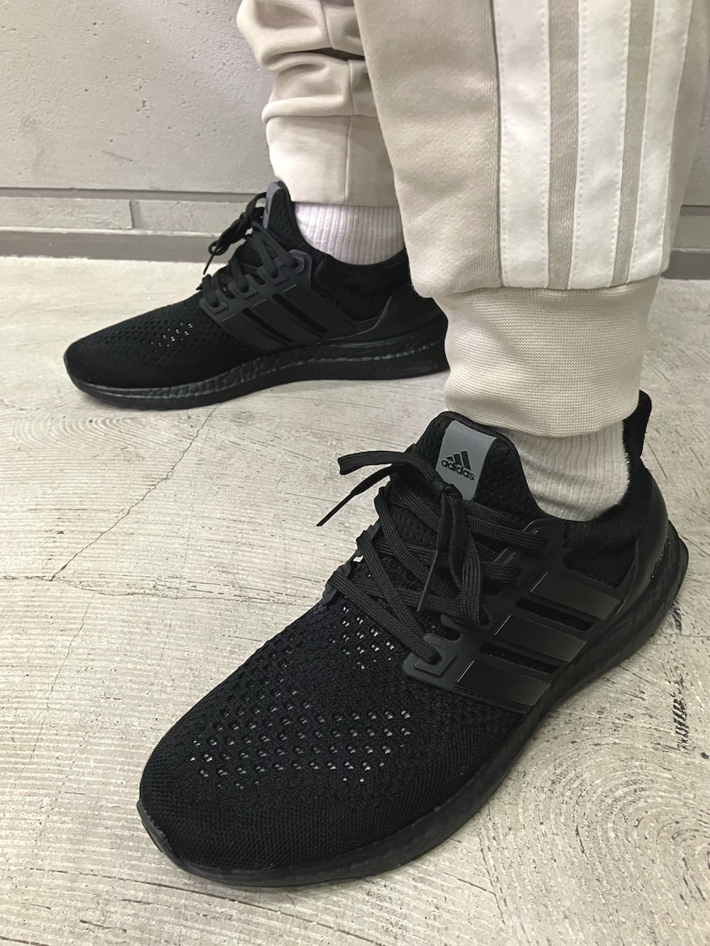 ホワイト系のスウェット、グレー系のスウェットパンツ、ブラック系のスニーカーを着用したメンズの冬コーディネートの4枚目の写真