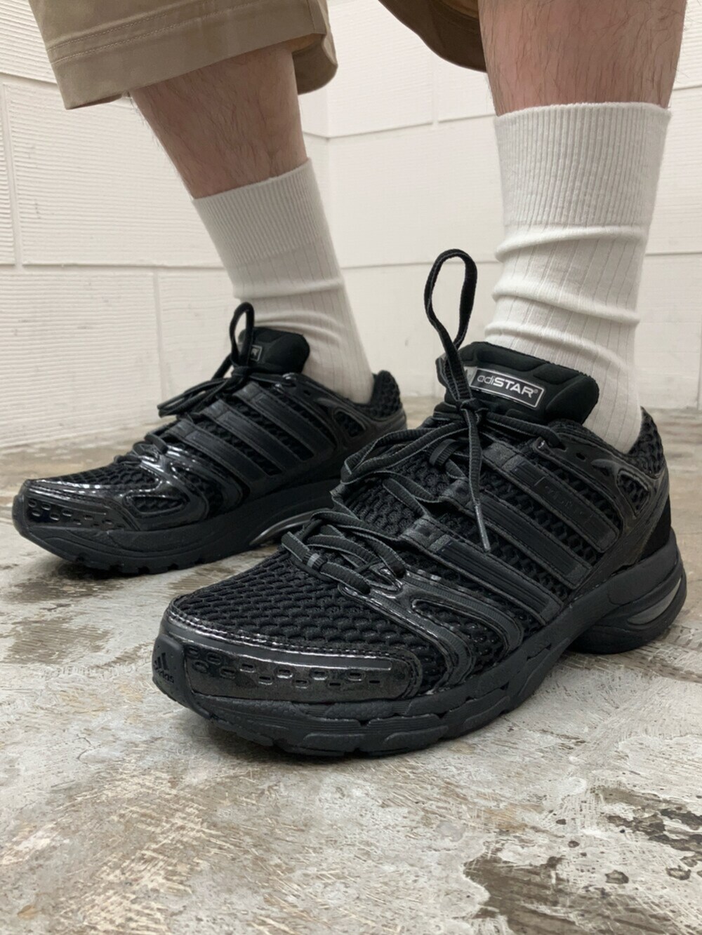 ブラック系のスニーカー、ホワイト系のトップス、ベージュ系のその他パンツを着用したメンズの夏コーディネートの6枚目の写真