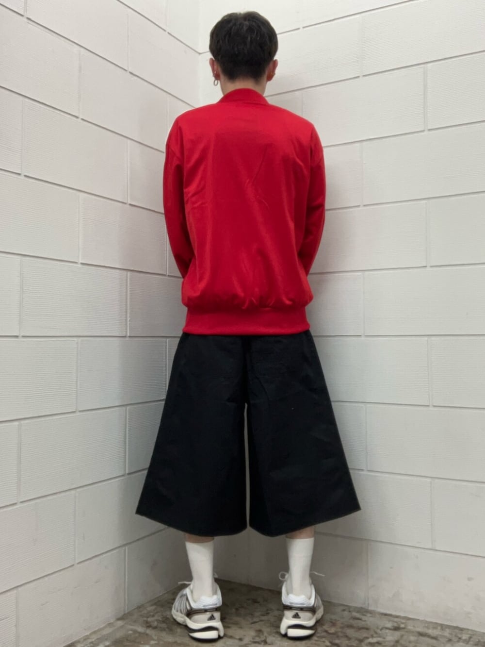 ホワイト系のスニーカー、レッド系のジャージ、ブラック系のその他パンツを着用したメンズの夏コーディネートの2枚目の写真