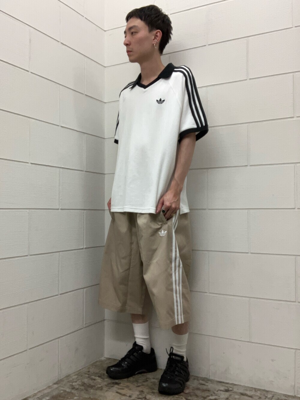 ブラック系のスニーカー、ホワイト系のトップス、ベージュ系のその他パンツを着用したメンズの夏コーディネートの3枚目の写真