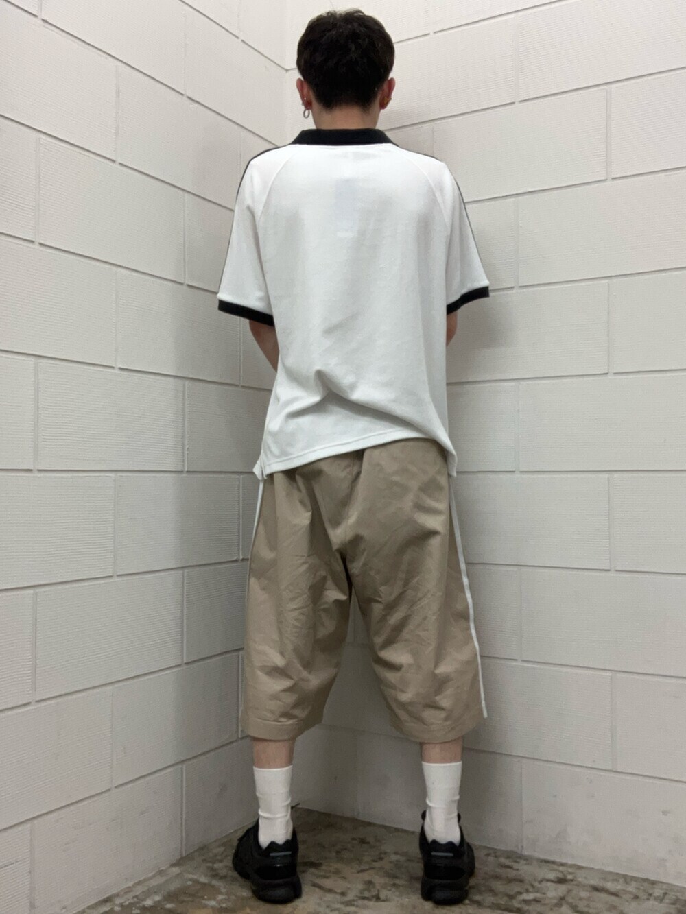 ブラック系のスニーカー、ホワイト系のトップス、ベージュ系のその他パンツを着用したメンズの夏コーディネートの2枚目の写真