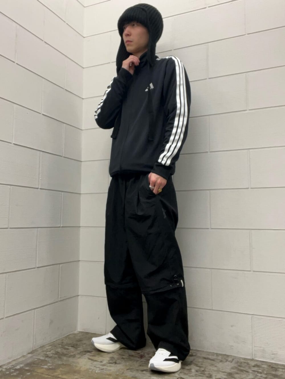 ブラック系のその他パンツ、ブラック系のトップス、ホワイト系のスニーカーを着用したメンズの冬コーディネートの2枚目の写真