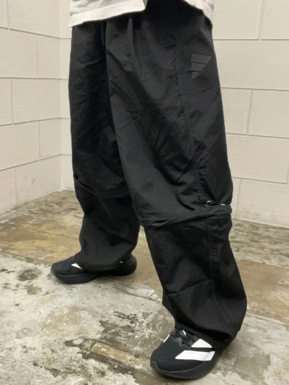 ブラック系のその他パンツ、ブラック系のスニーカー、グレー系のパーカーを着用したメンズの冬コーディネートの5枚目の写真