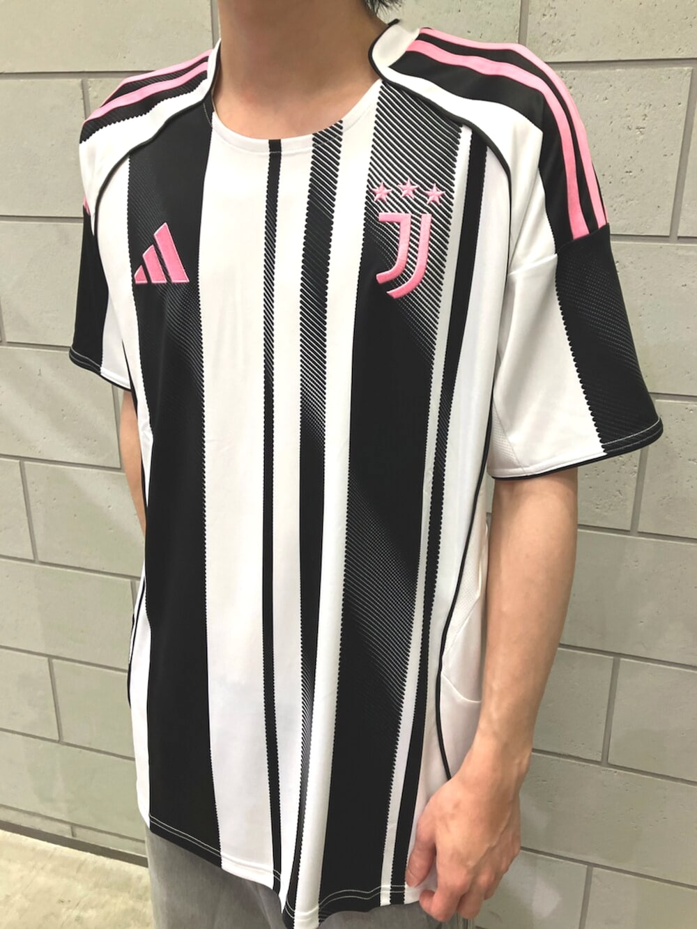 ブラック系のスニーカー、ホワイト系のTシャツ/カットソー、ブルー系のデニムパンツを着用したメンズの夏コーディネートの4枚目の写真