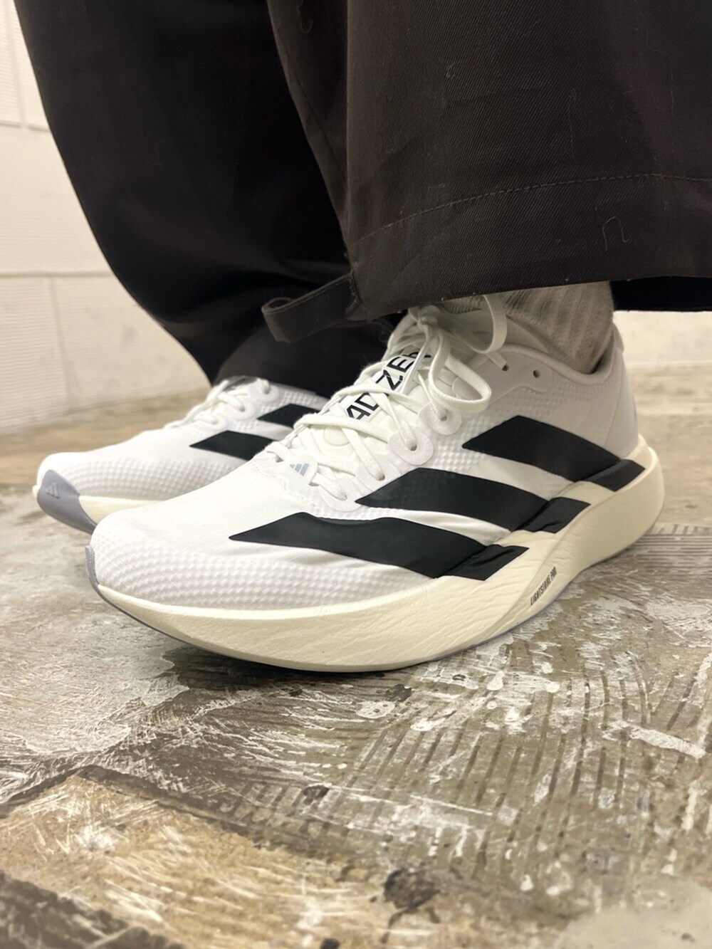 レッド系のTシャツ/カットソー、ホワイト系のスニーカーを着用したメンズの冬コーディネートの6枚目の写真