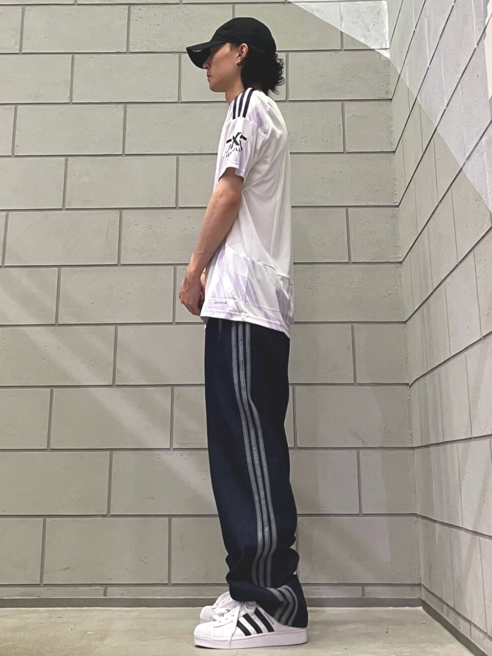 ホワイト系のスニーカー、ブルー系のデニムパンツ、ホワイト系のTシャツ/カットソーを着用したメンズの夏コーディネートの2枚目の写真